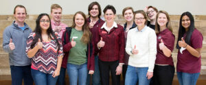 faculty with students all doing thumbs up